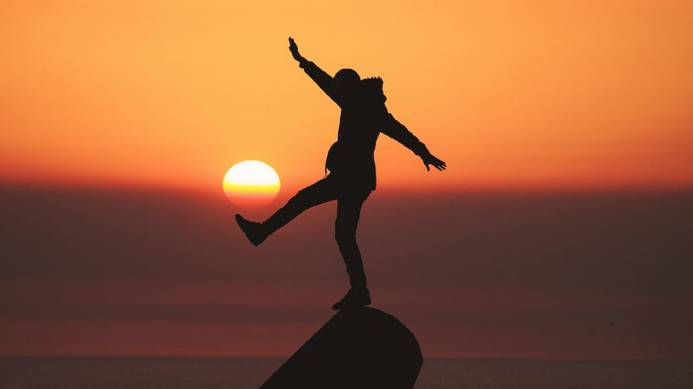 Image of a man above a rock in balance