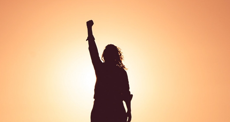 Image of a woman lifting one arm with energy