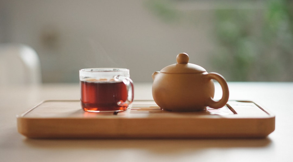 Image of a cup of ginseng tea and a teapot, highlighting the benefits for body and mind.