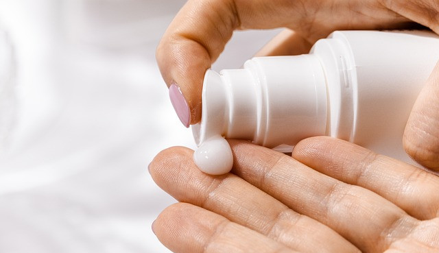 Image of a woman applying a cream in hands