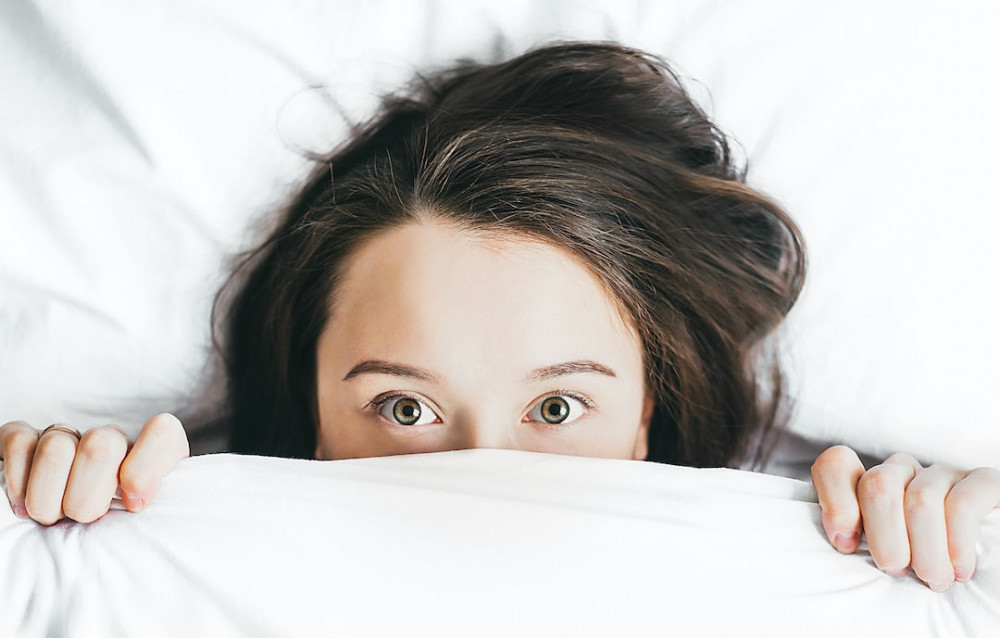 Image of a woman in bed with insomnia