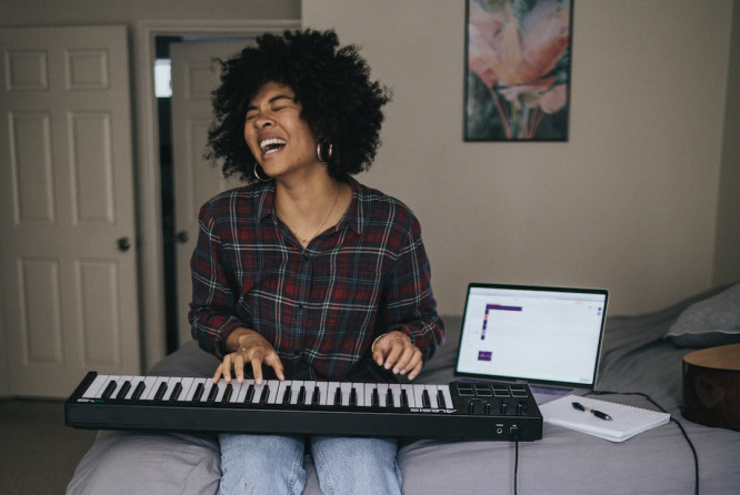 Image of a woman playing piano and singing