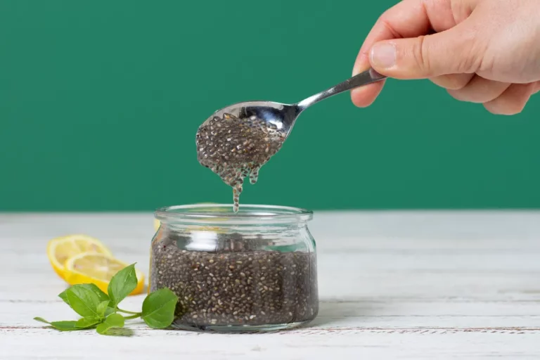 Close up of a hand holding a spoon with chia seeds