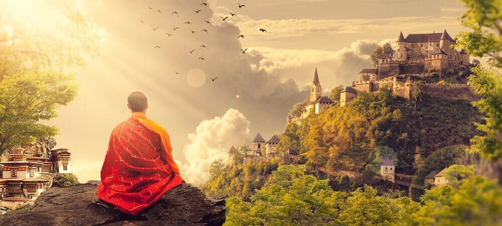 Person peacefully meditating in front of a temple in the mountains, promoting the benefits of Reiki for mental wellbeing.